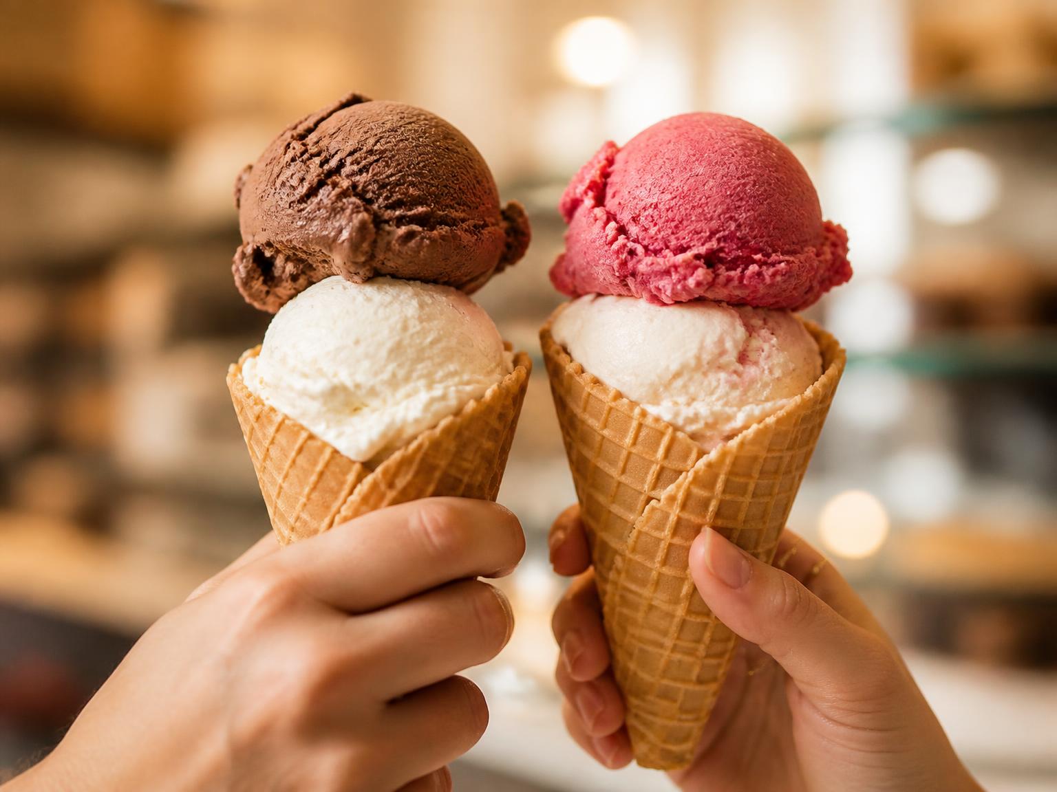 Deux cornets gaufrés garnis de boules de crème glacée vanille, chocolat et sorbet framboise
